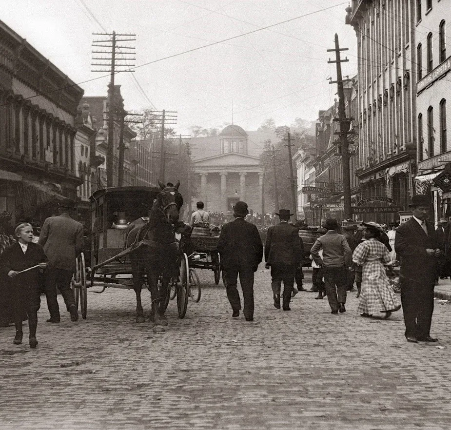St. Clair Avenue cobblestone street with courthouse steps, pedestrians, and early utility poles.