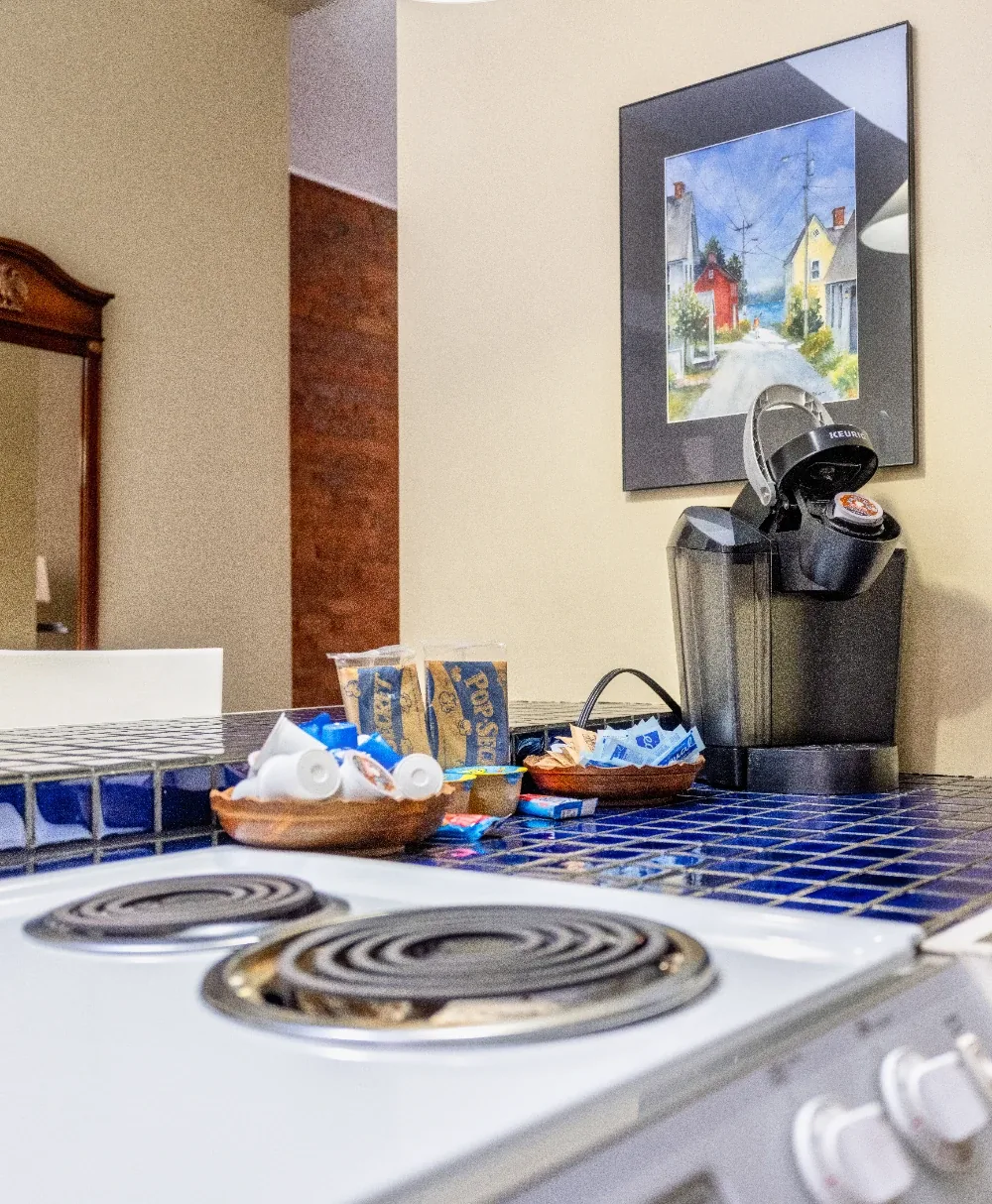 Cozy blue tiled kitchen coffee nook with coil stove and single-serve coffee maker
