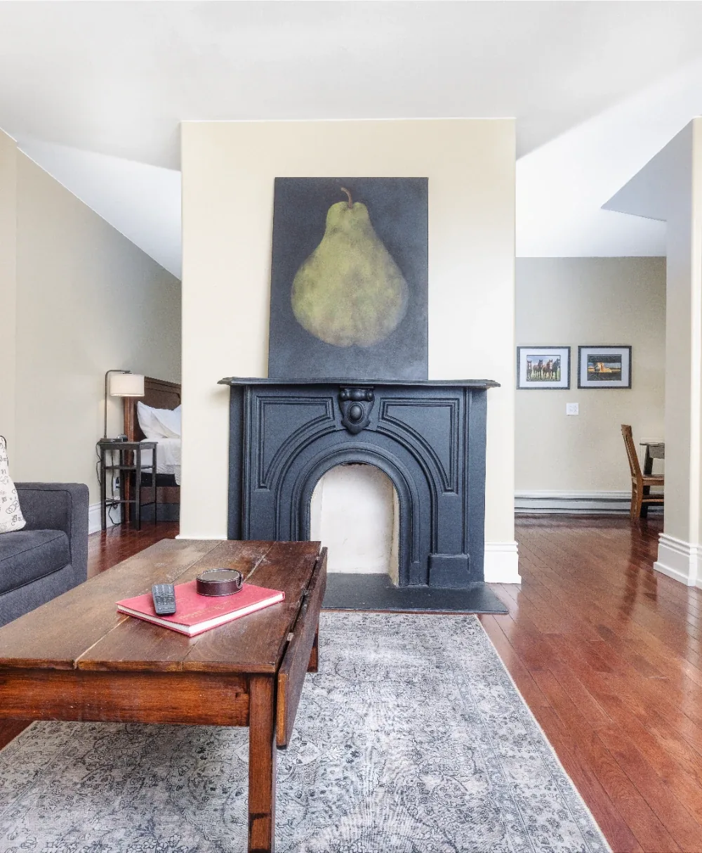 Modern living room with black fireplace, pear wall art, and coffee table on rug